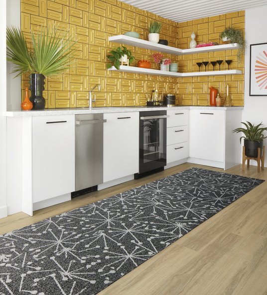 Kitchen with gold backsplash featuring FLOR Mod Cafe runner rug shown in Black